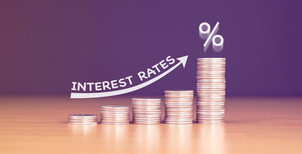 Stacked us quarter coins on wooden table with white illustration shows increasing of interest rates.