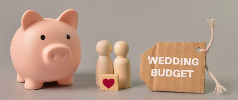 Piggy bank, people figures and label tag written with wedding budget.