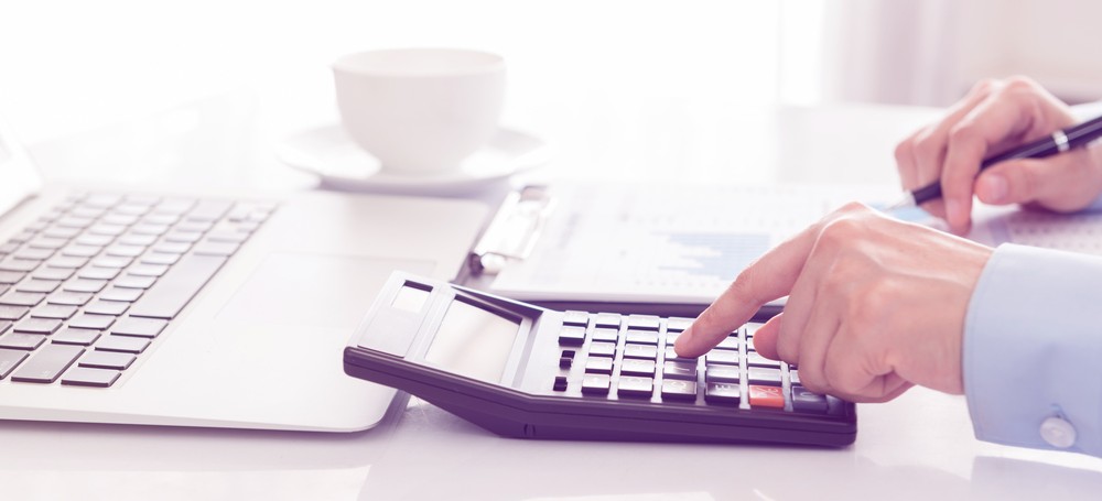 Businessman using a calculator to calculate the numbers.