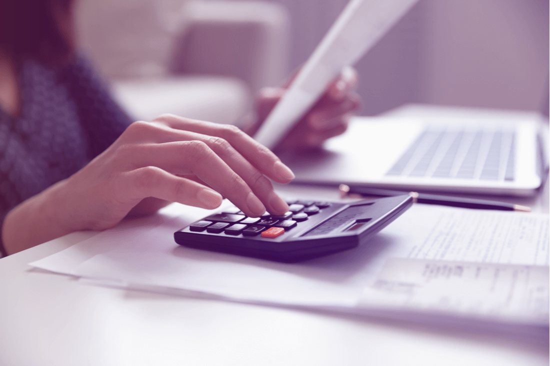 Close up young woman calculating domestic expenses involved in financial paperwork.