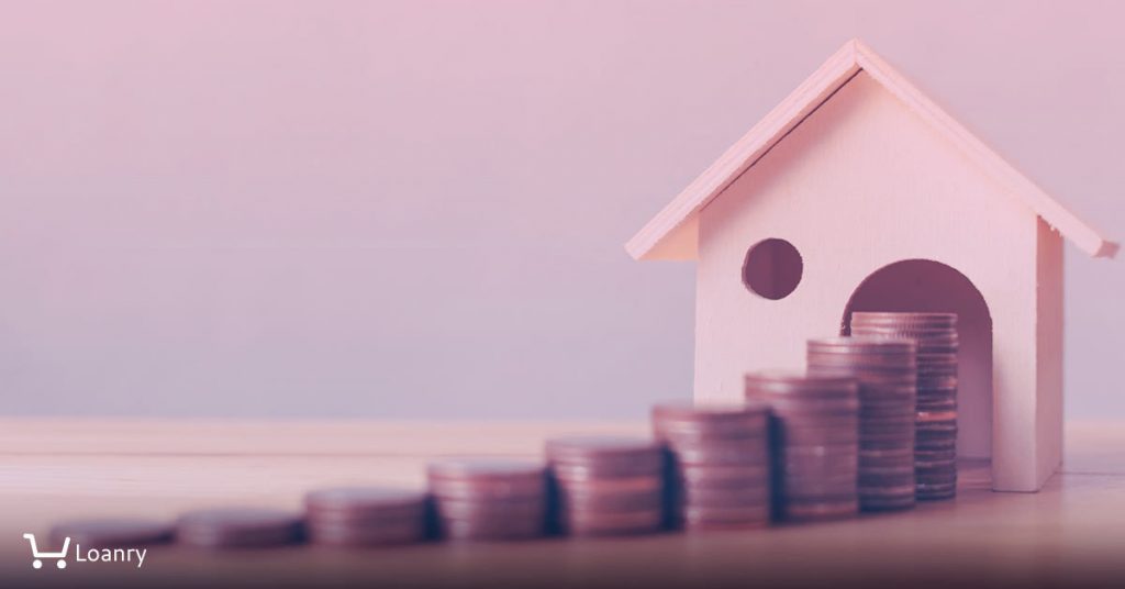Coins and a toy house on a desk