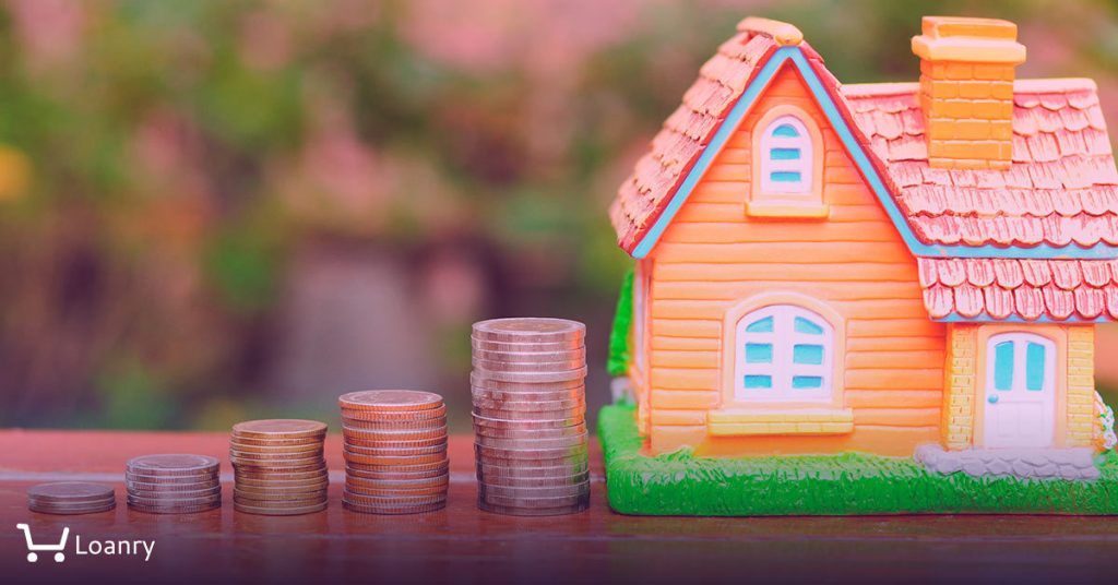 Toy house and coins on the desk