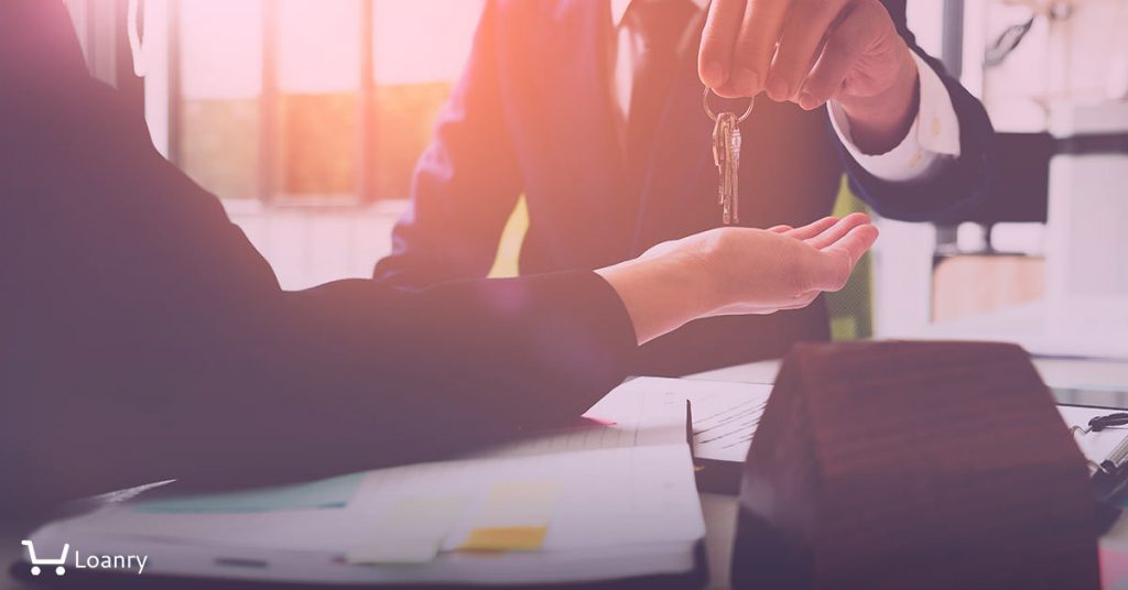 Estate agent giving house keys to woman and sign agreement in office