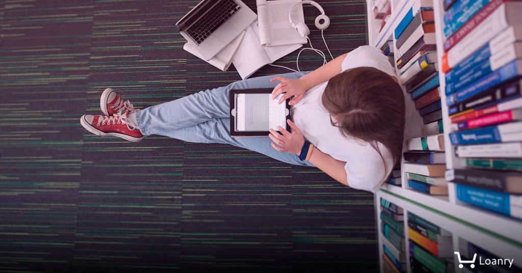 Female student study in library using tablet and searching internet while Listening music