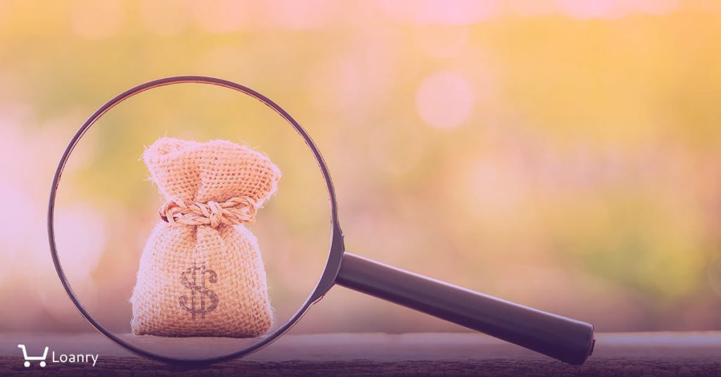 Magnifying glass with searching for money bag put on the wood