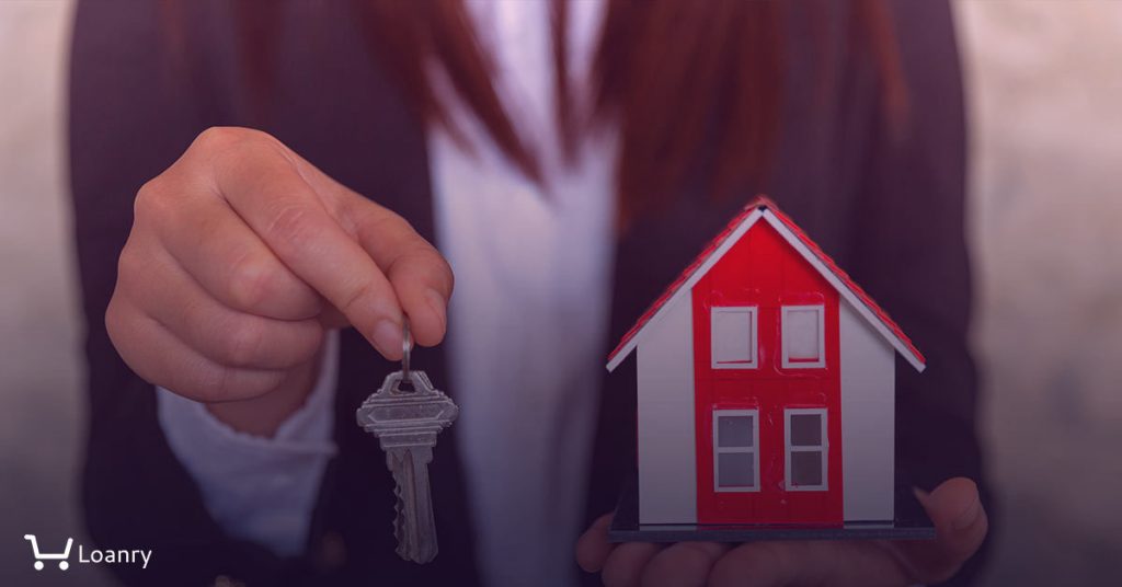 A real estate agent with a key. Red roof house.