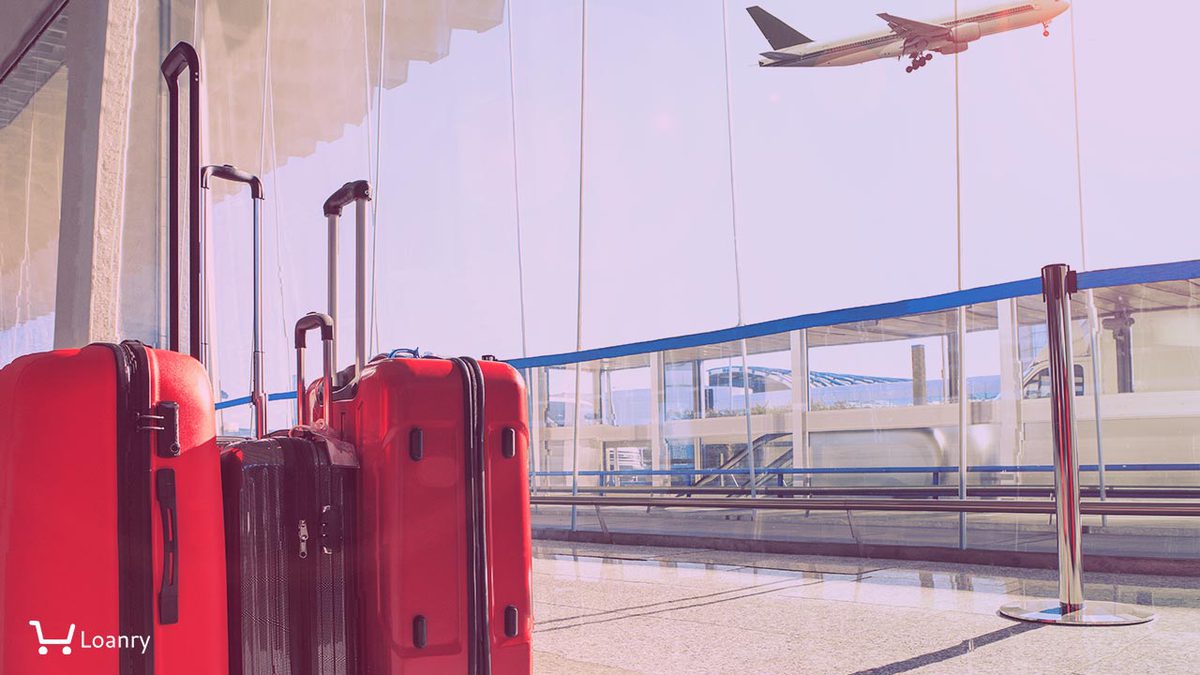 Stack of traveling luggage in airport terminal and passenger plane flying over sky