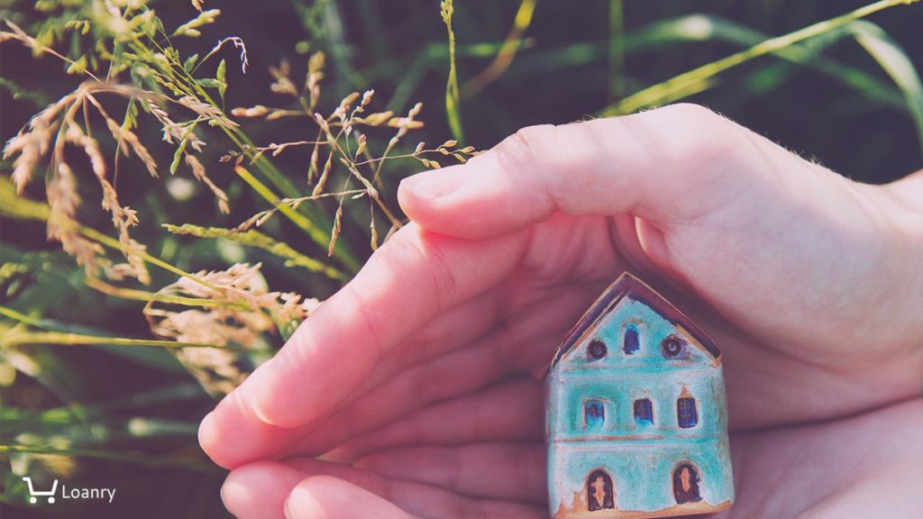Female hands holding small house, natural background