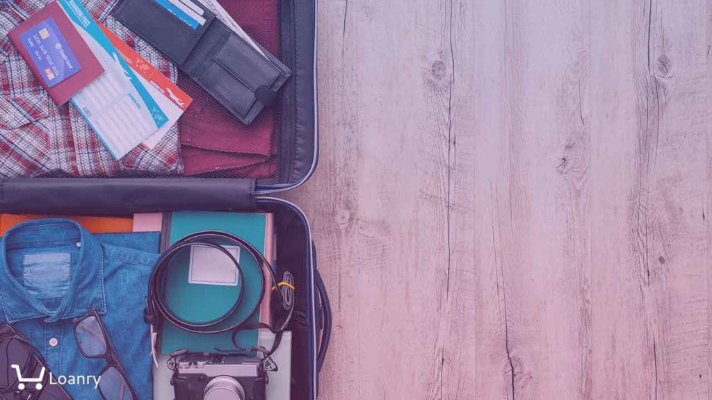 Open traveler's bag with clothing, accessories, credit card, tickets and passport