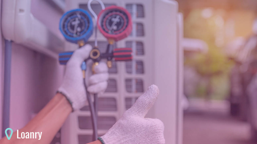 Repairman on the floor fixing air conditioning system