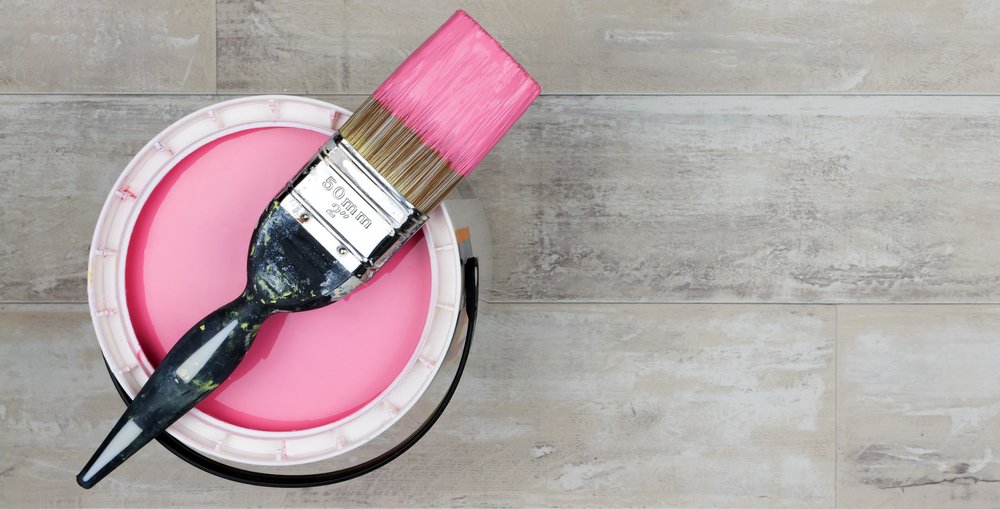 Looking down on a can of Pink Paint with a loaded brush.